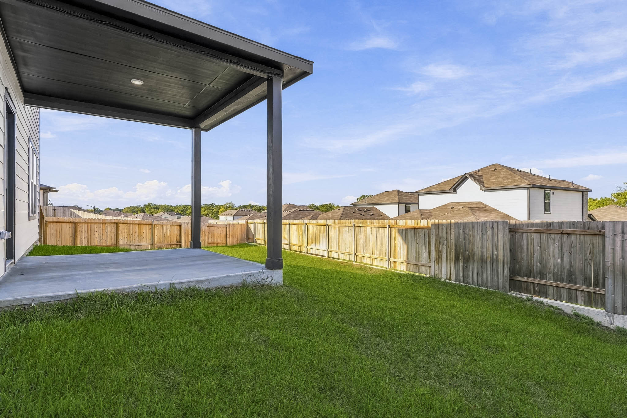 A fenced in yard with a house in the background.