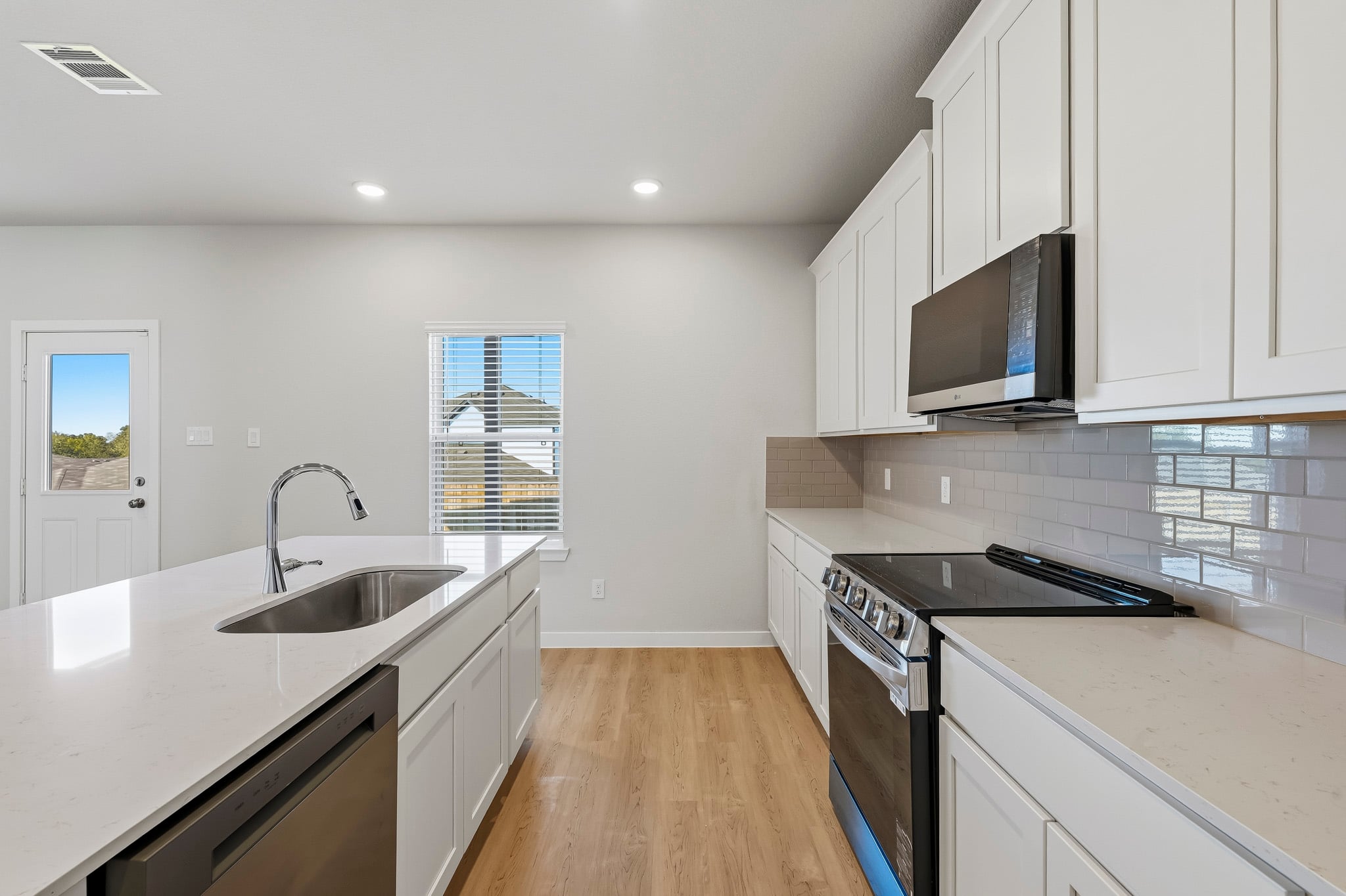 A kitchen with white cabinets.