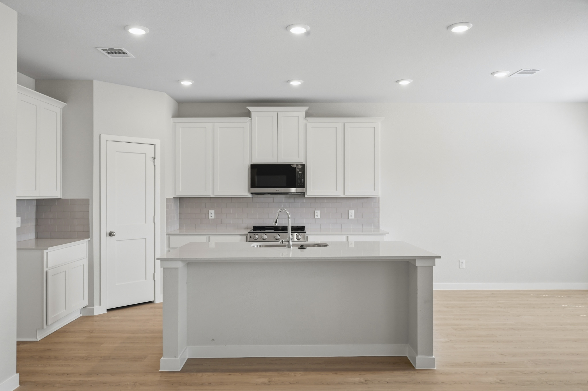 A kitchen with white cabinets.