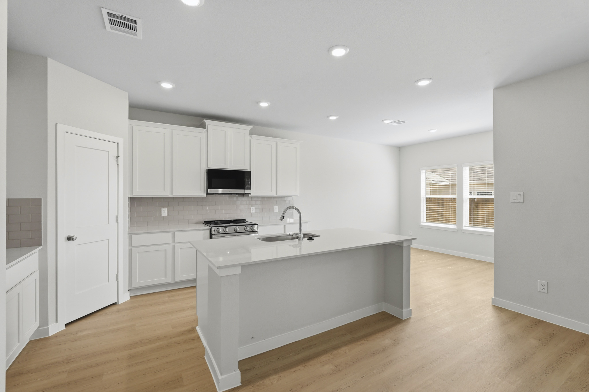 A kitchen with white cabinets.