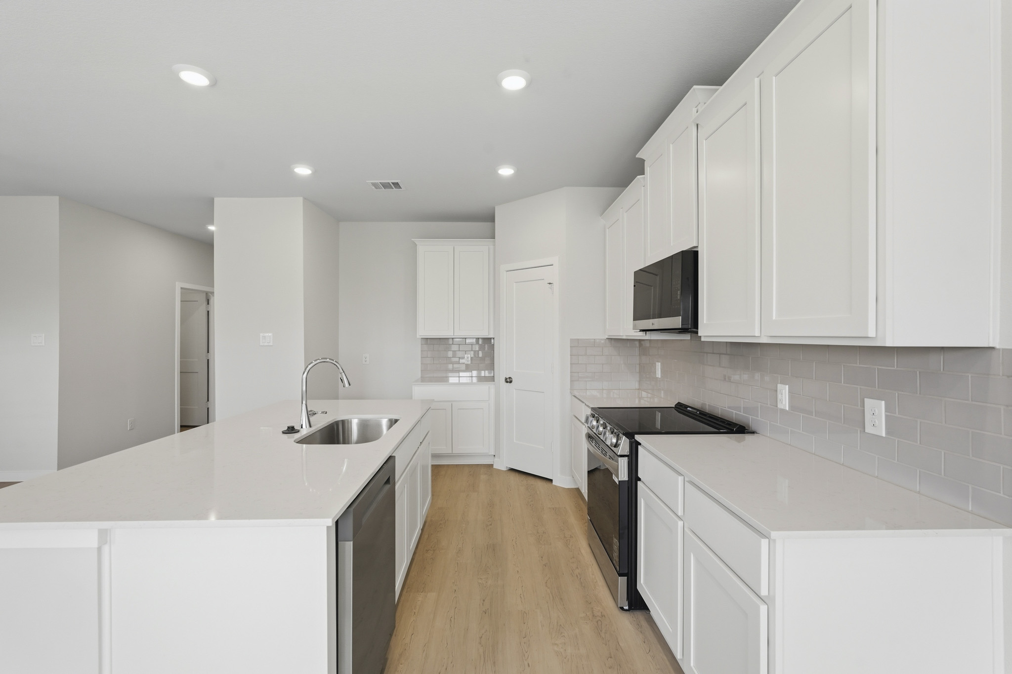 A kitchen with white cabinets.