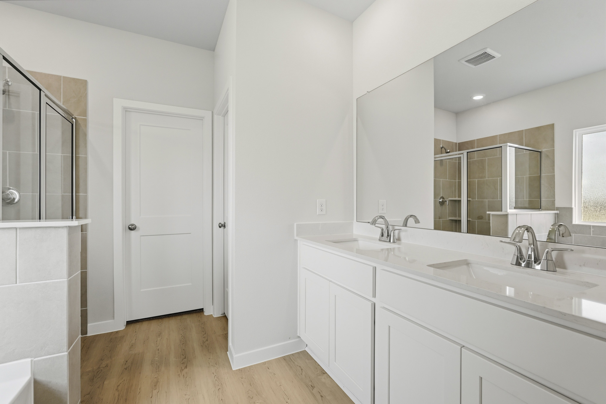 A bathroom with white cabinets.
