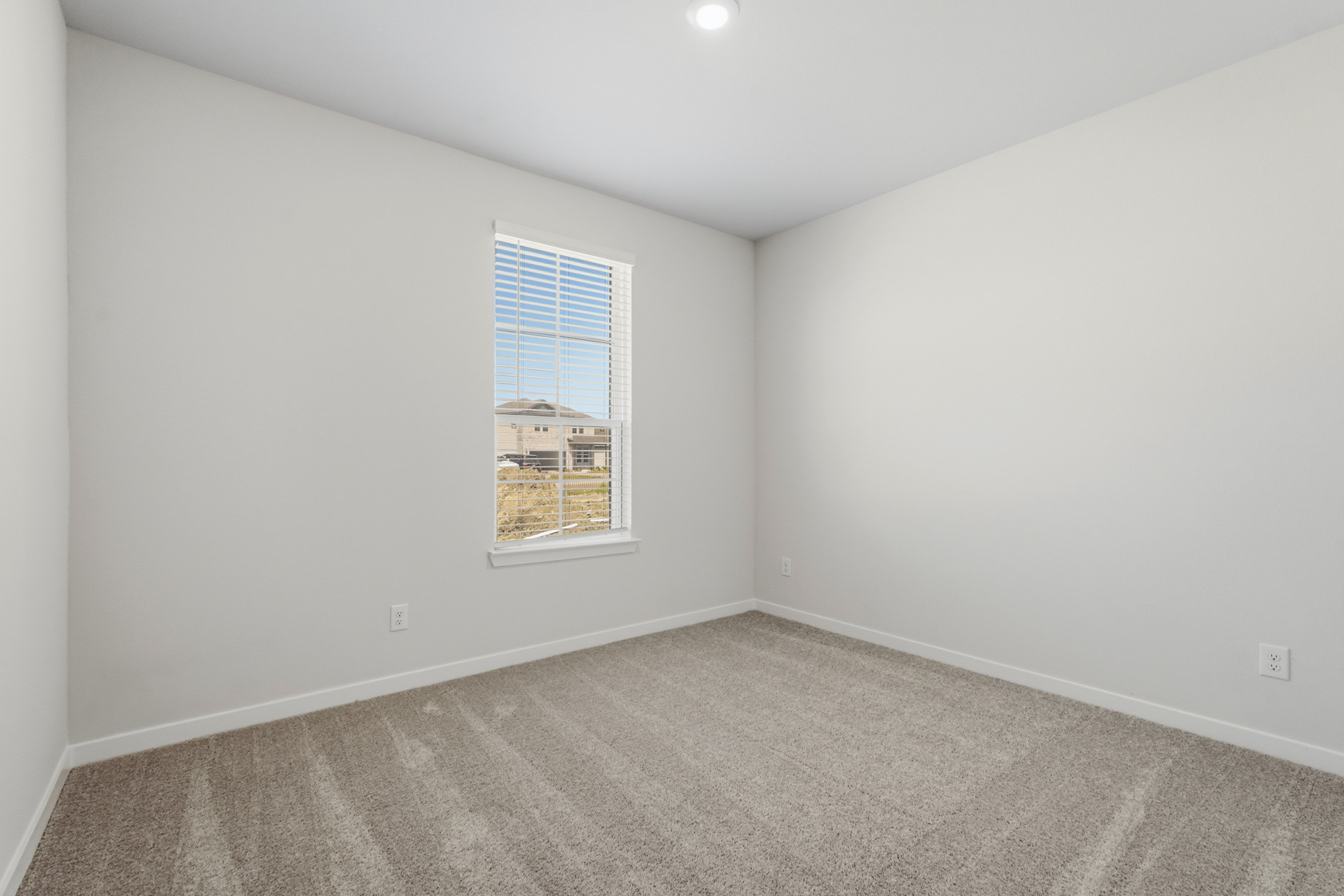 A room with a window and a carpet.