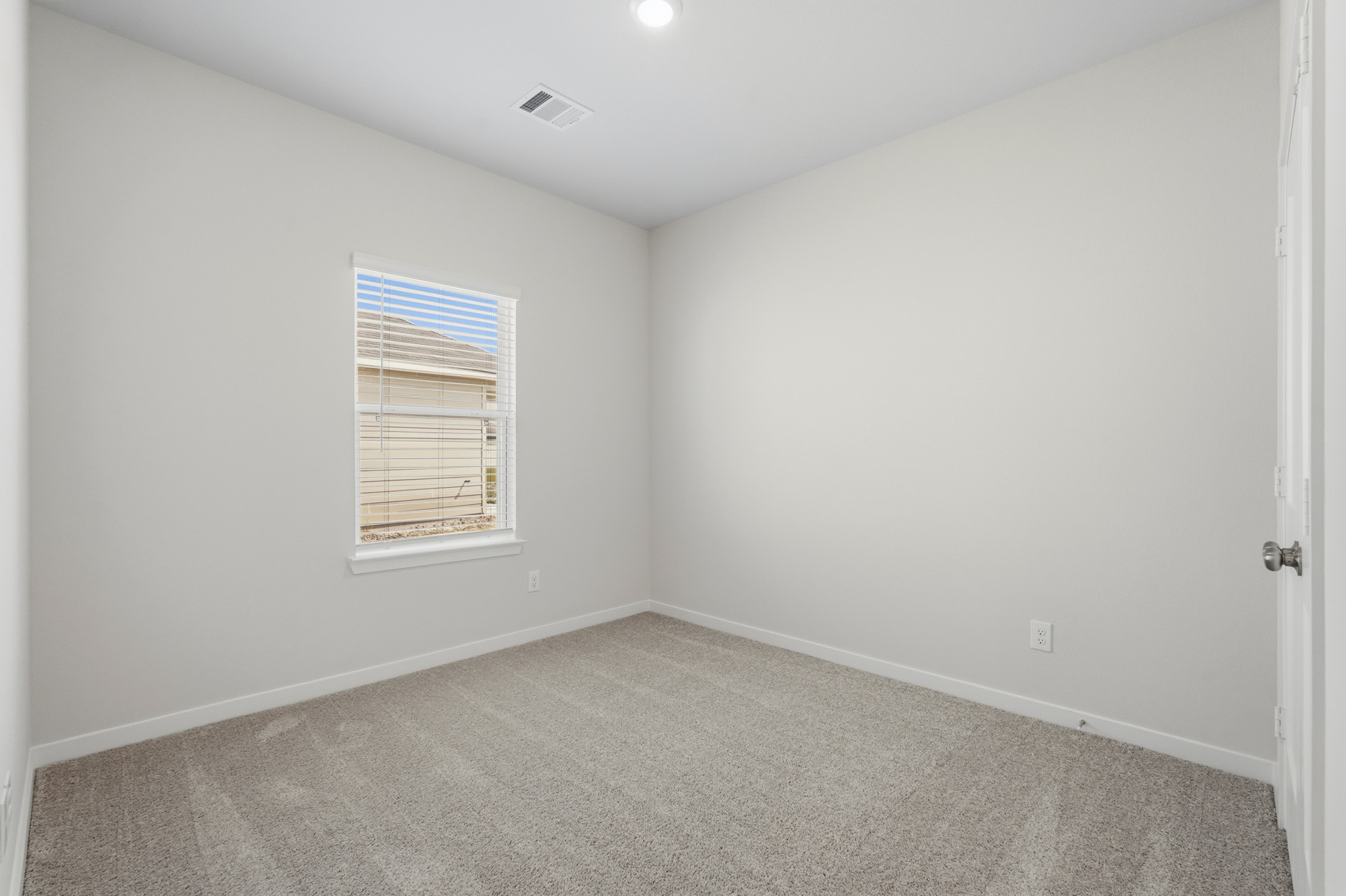 A room with a carpet and a window.