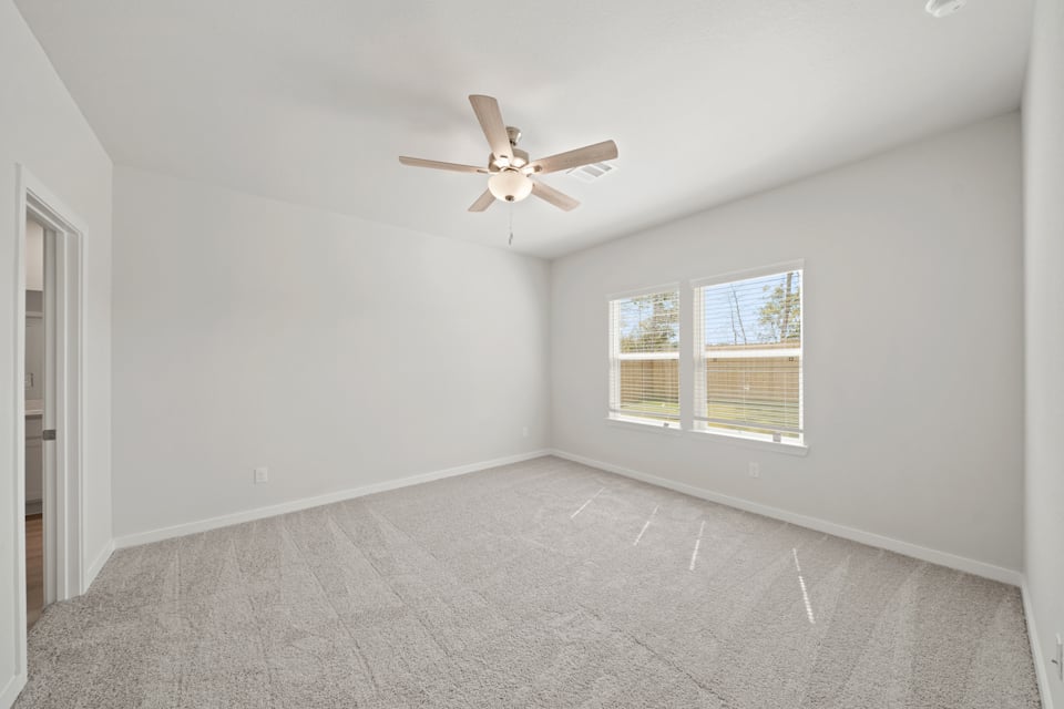 A room with a ceiling fan and a window.