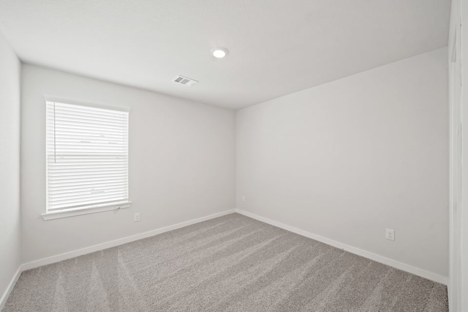 A room with a carpet and a window.