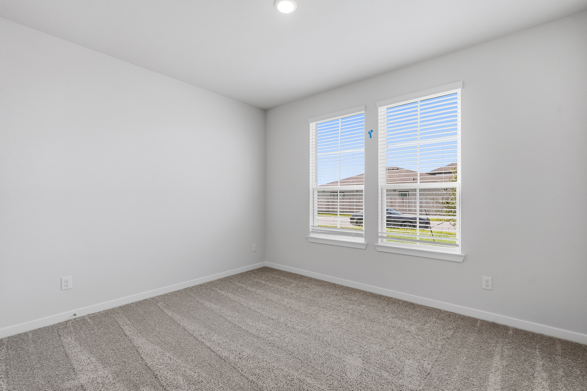 A room with a window and a white wall.