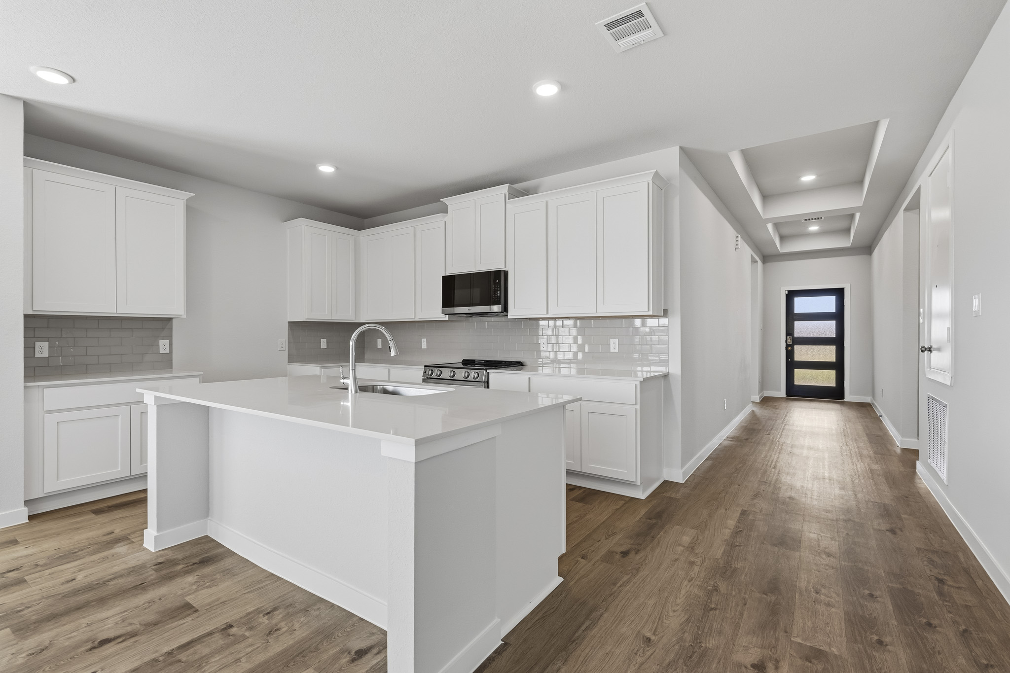 A kitchen with white cabinets.