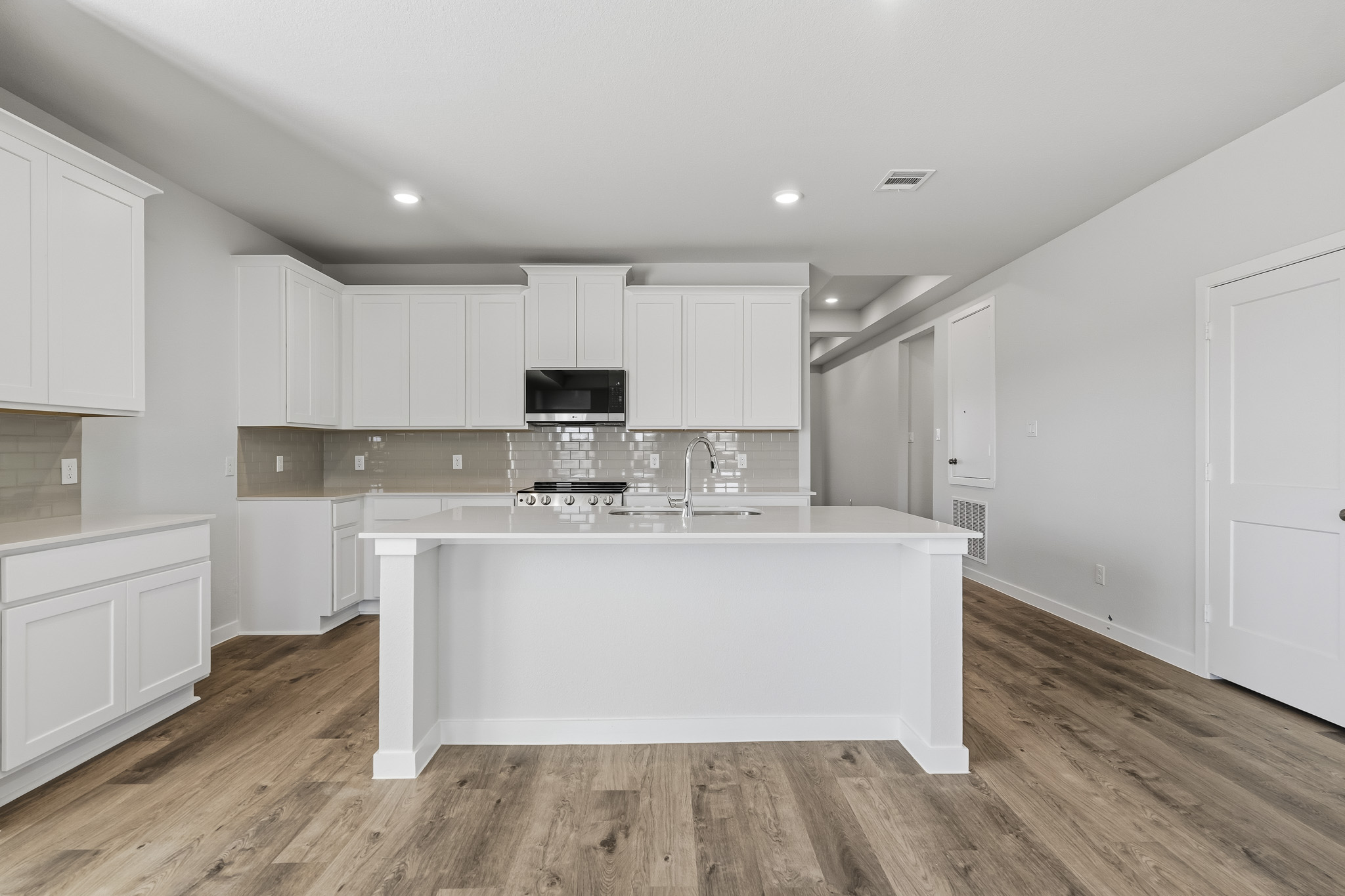 A kitchen with white cabinets.