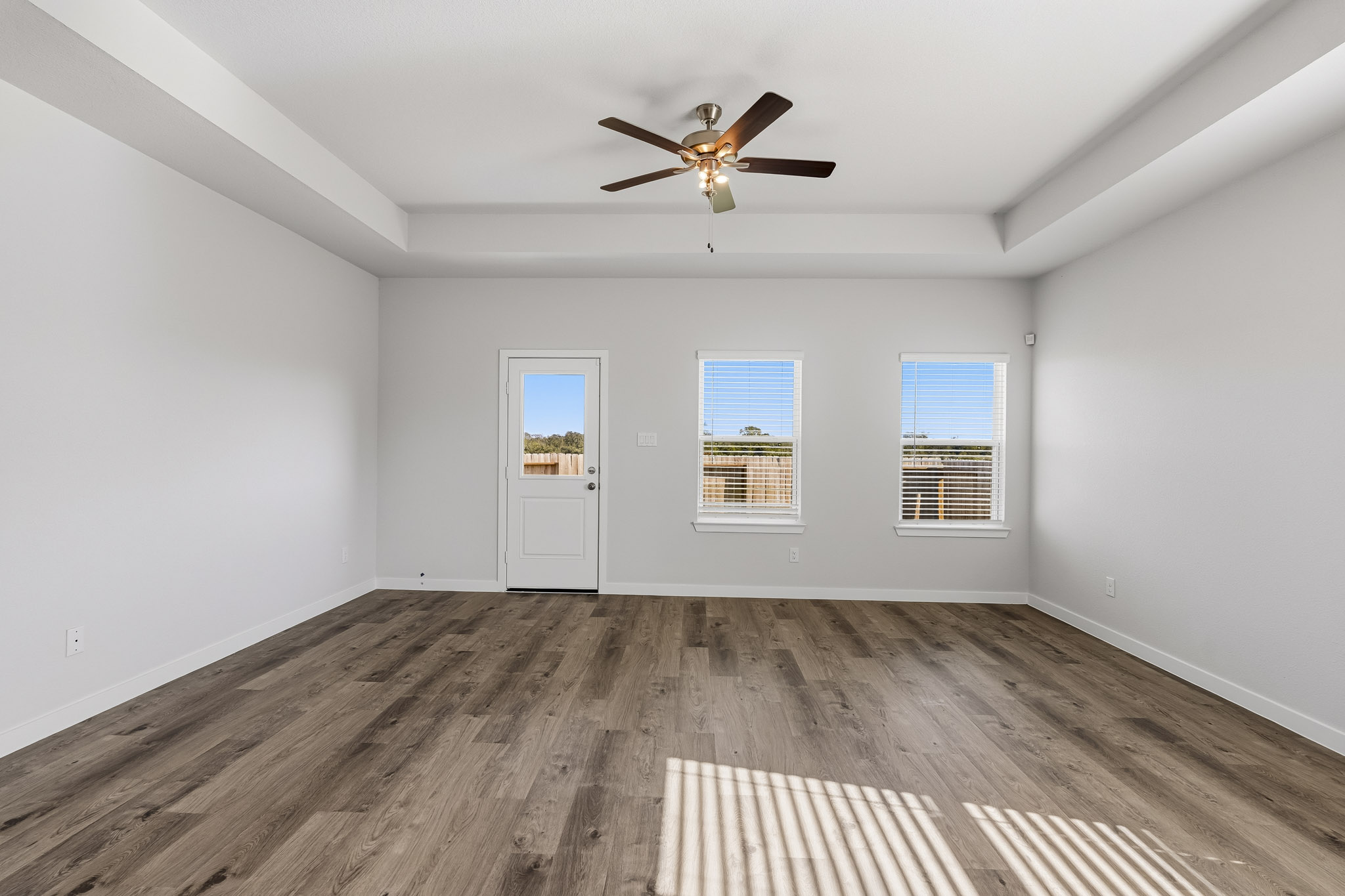 A room with a wood floor and a ceiling fan.
