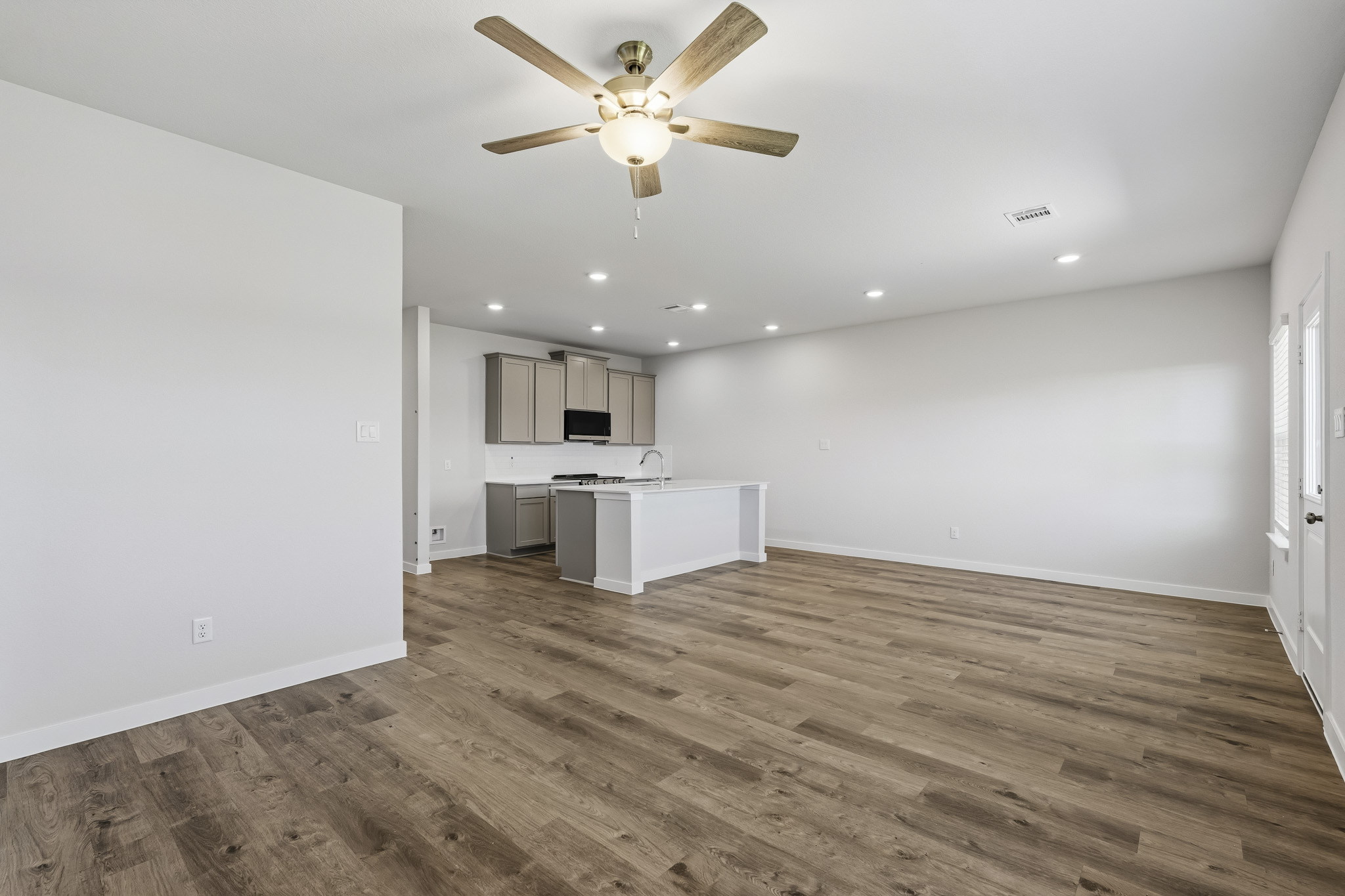 A room with a wood floor and a ceiling fan.