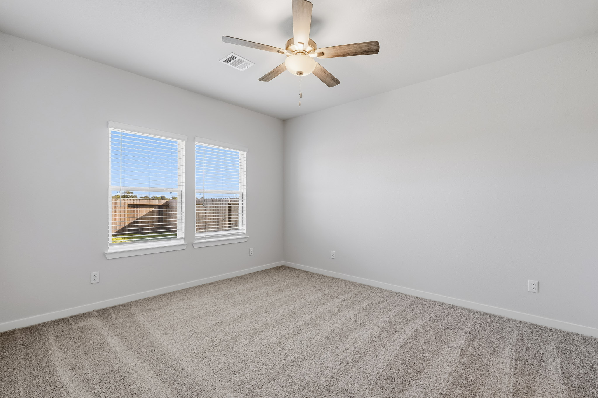 A room with a ceiling fan and a window.