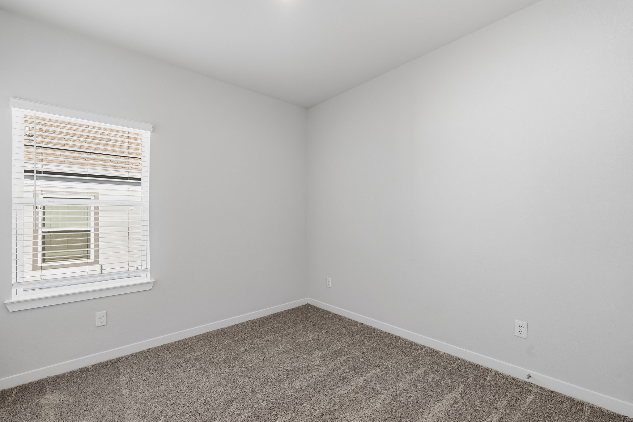 A room with a window and a carpet.