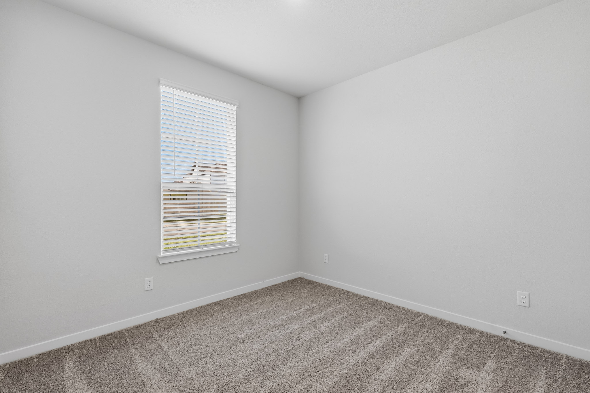 A room with a window and carpet.