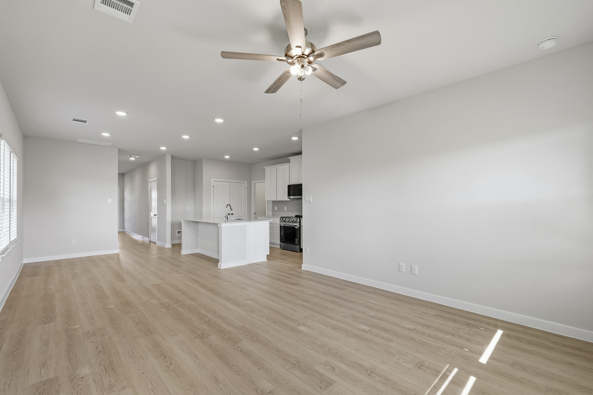 A large kitchen with a ceiling fan.