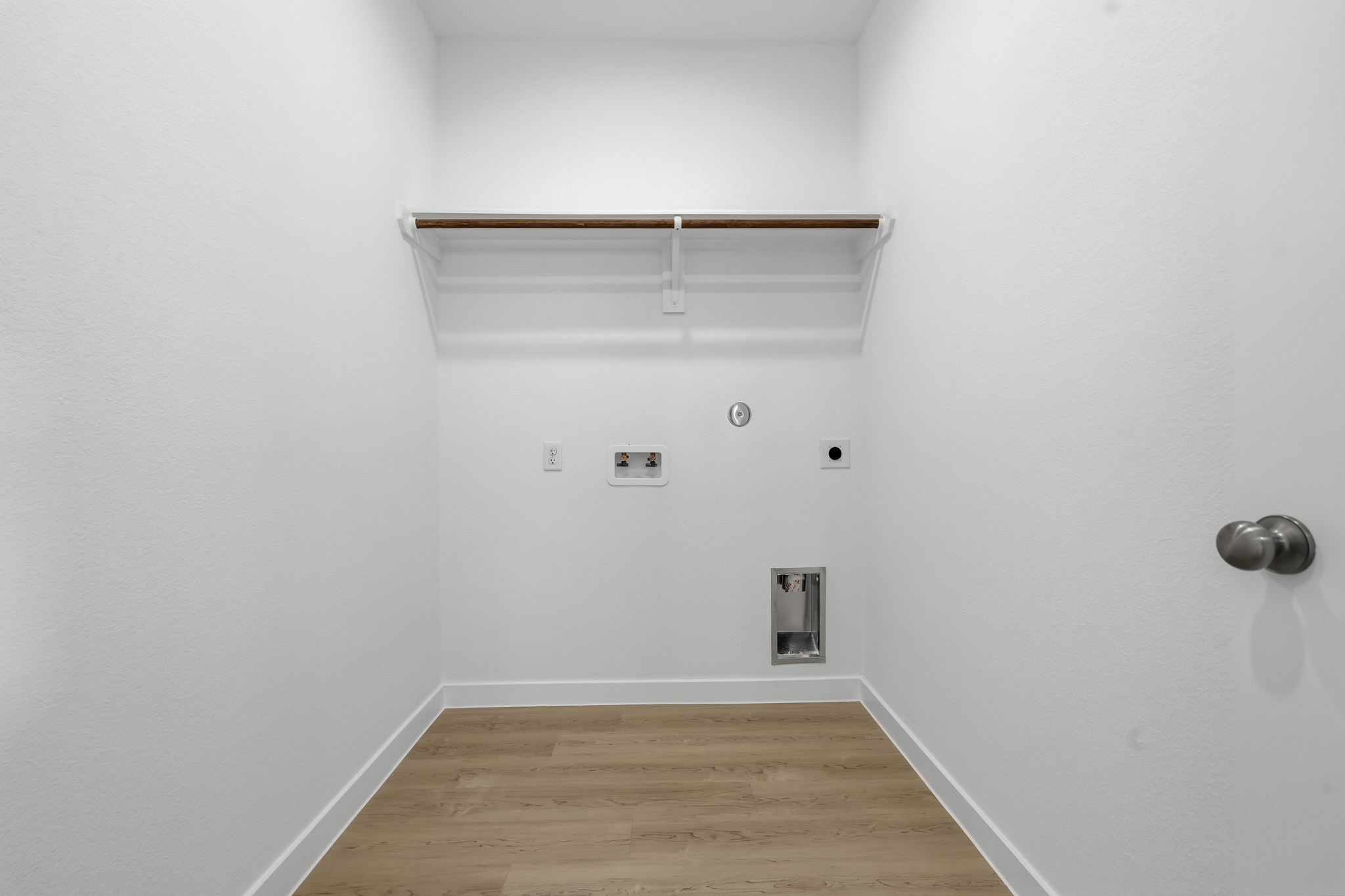 A white room with a wood floor.