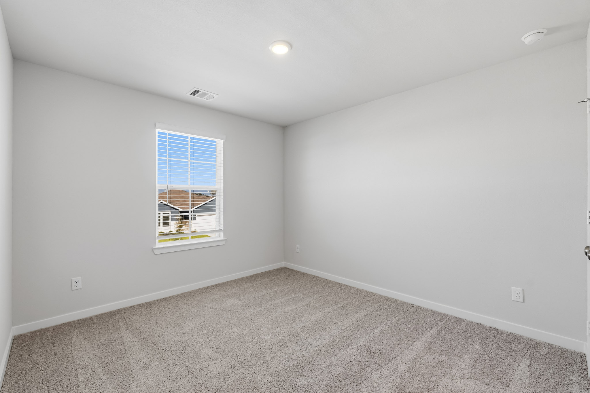 A room with a window and a carpet.