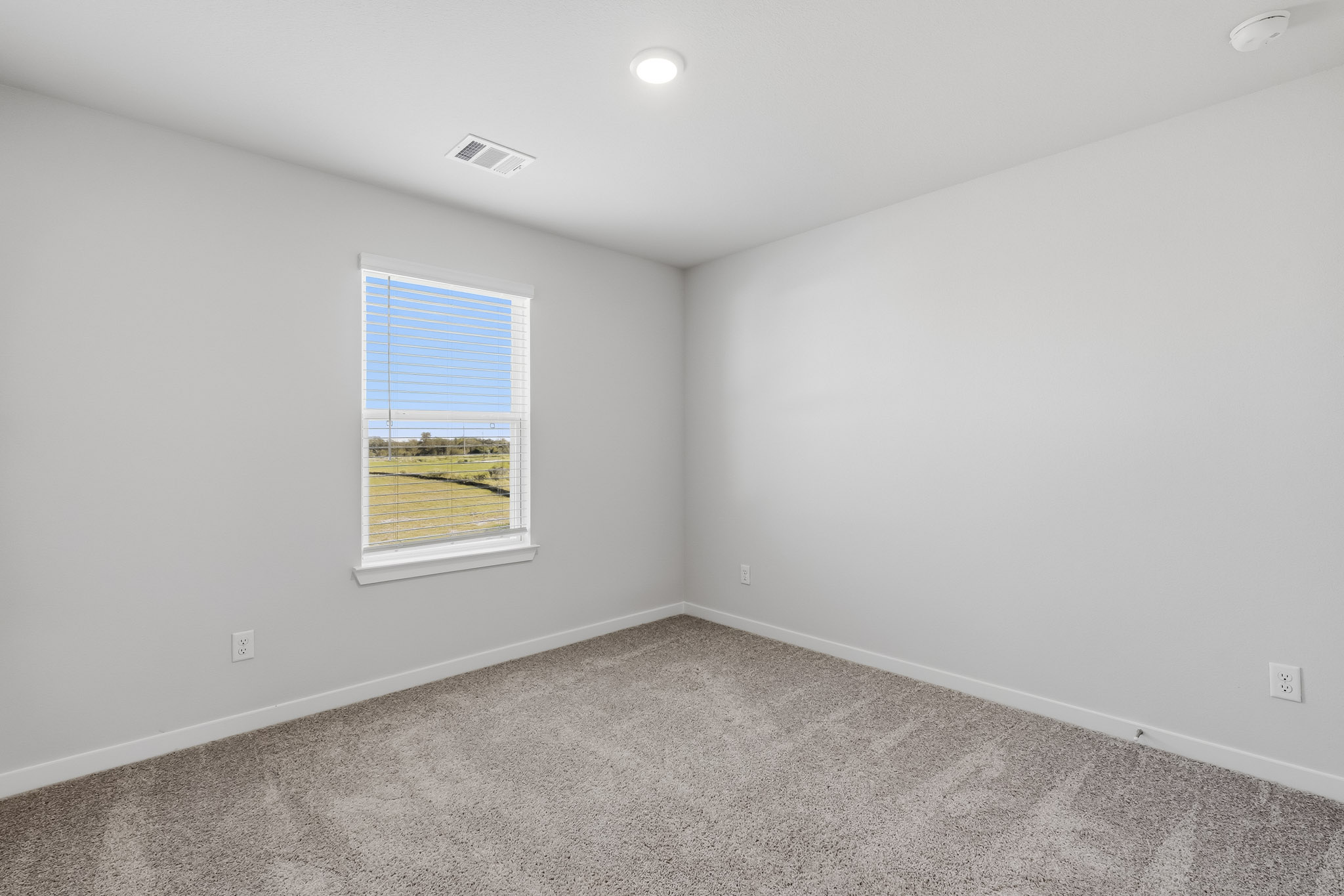 A room with a window and carpet.