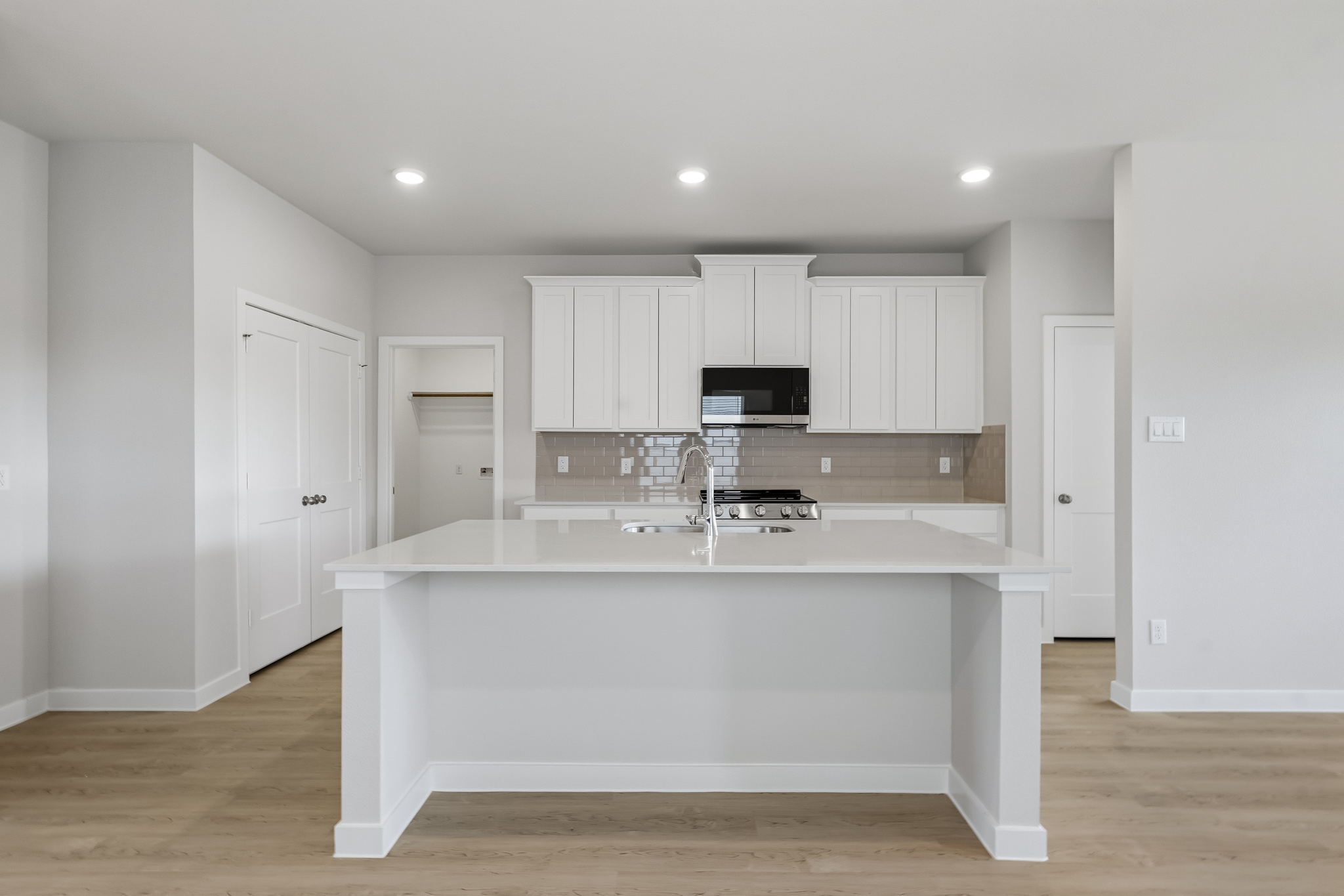 A kitchen with white cabinets.