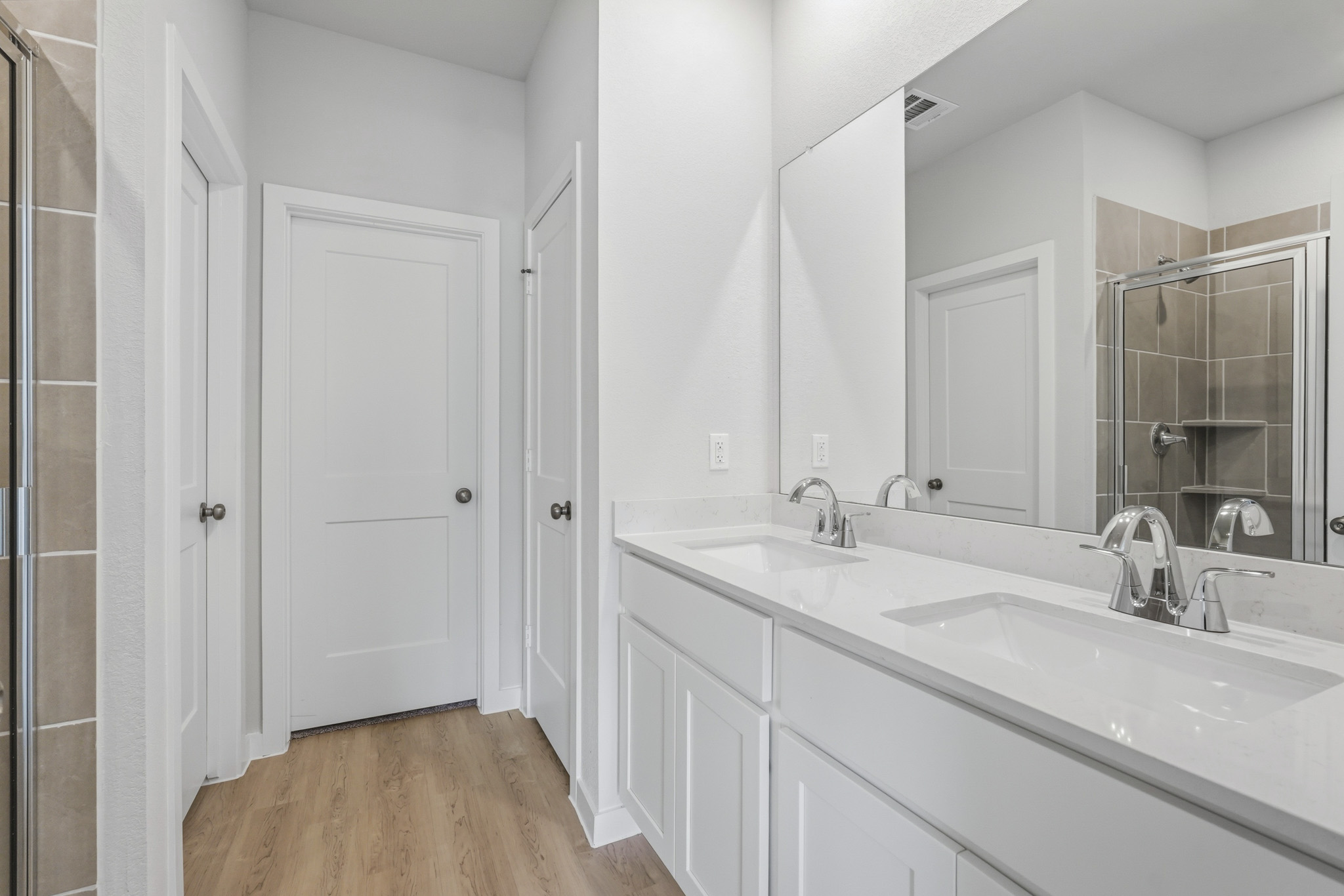 A bathroom with white cabinets.