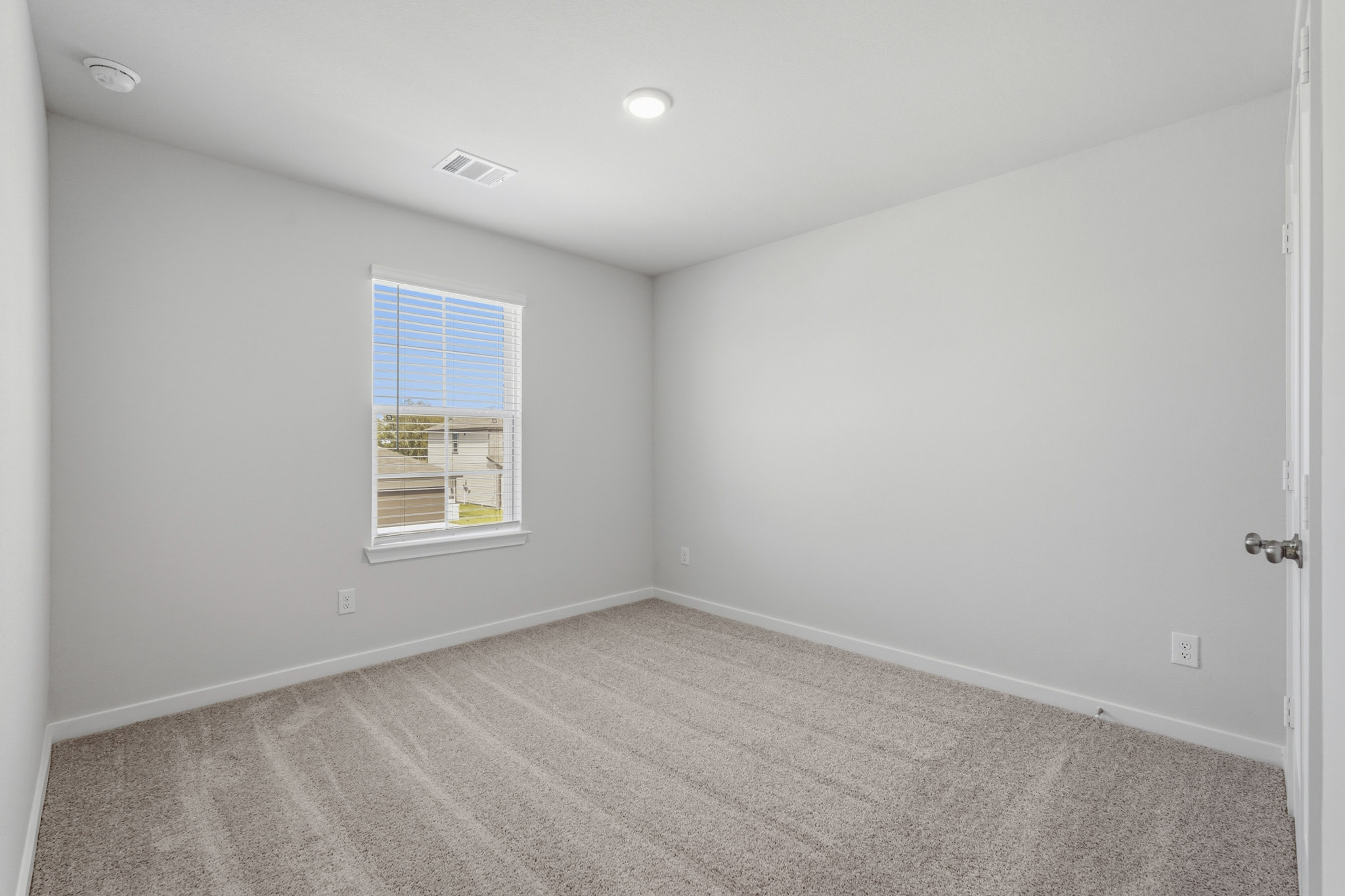 A room with a window and a carpet.
