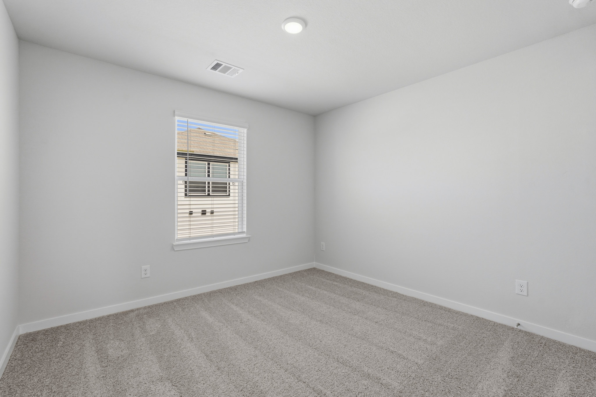 A room with a window and a vent.