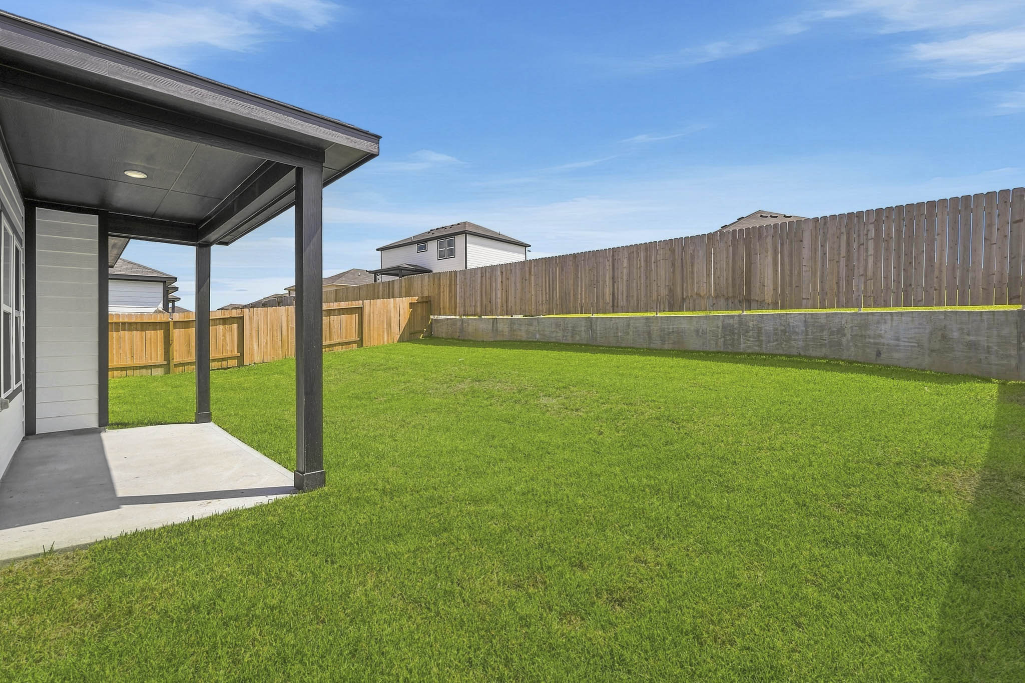 A fenced in yard with a building in the background.