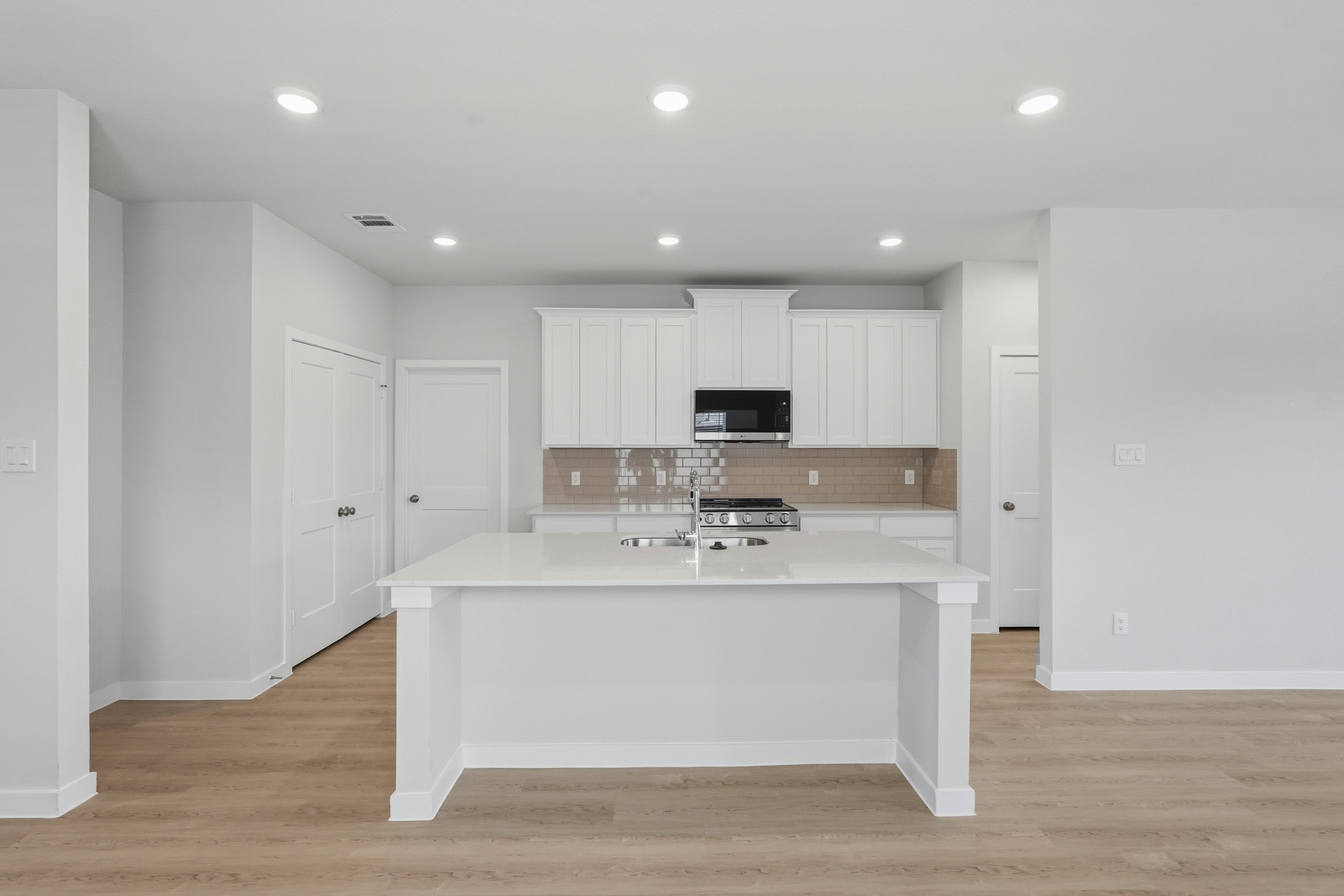A kitchen with white cabinets.
