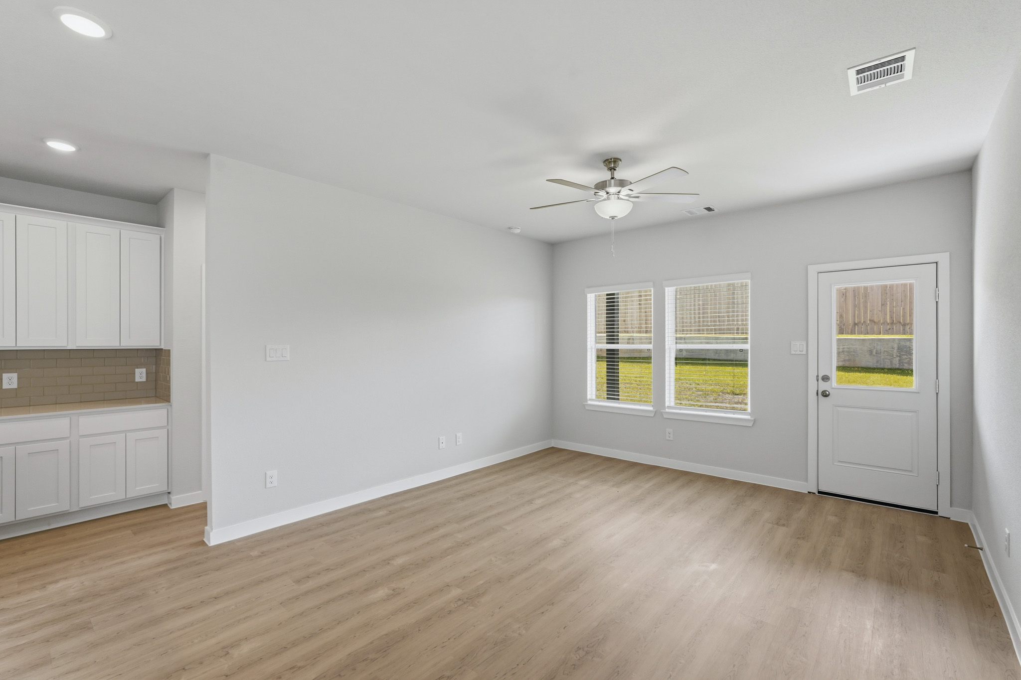 A room with white walls and a ceiling fan.