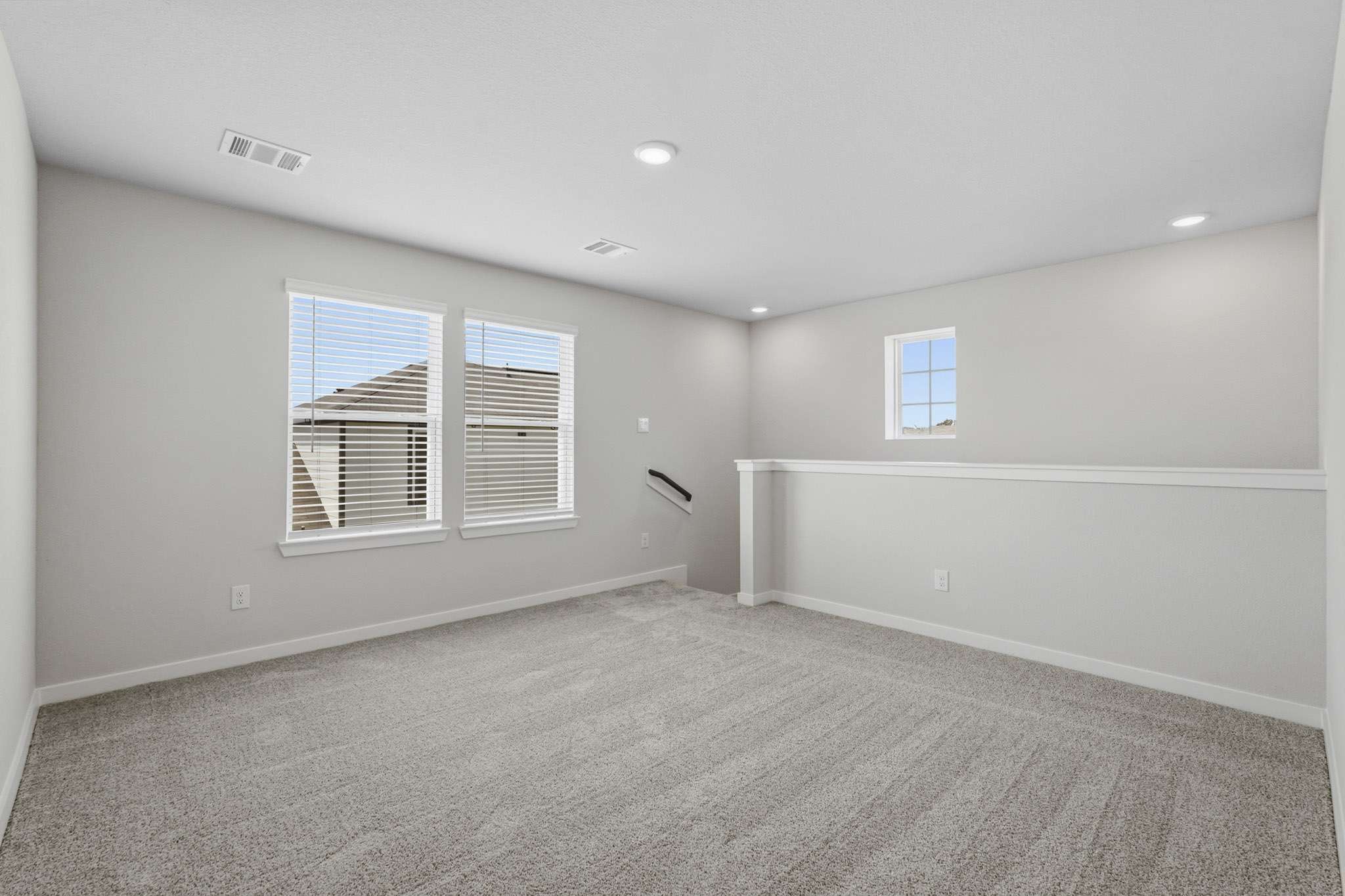 A room with a window and a white wall.