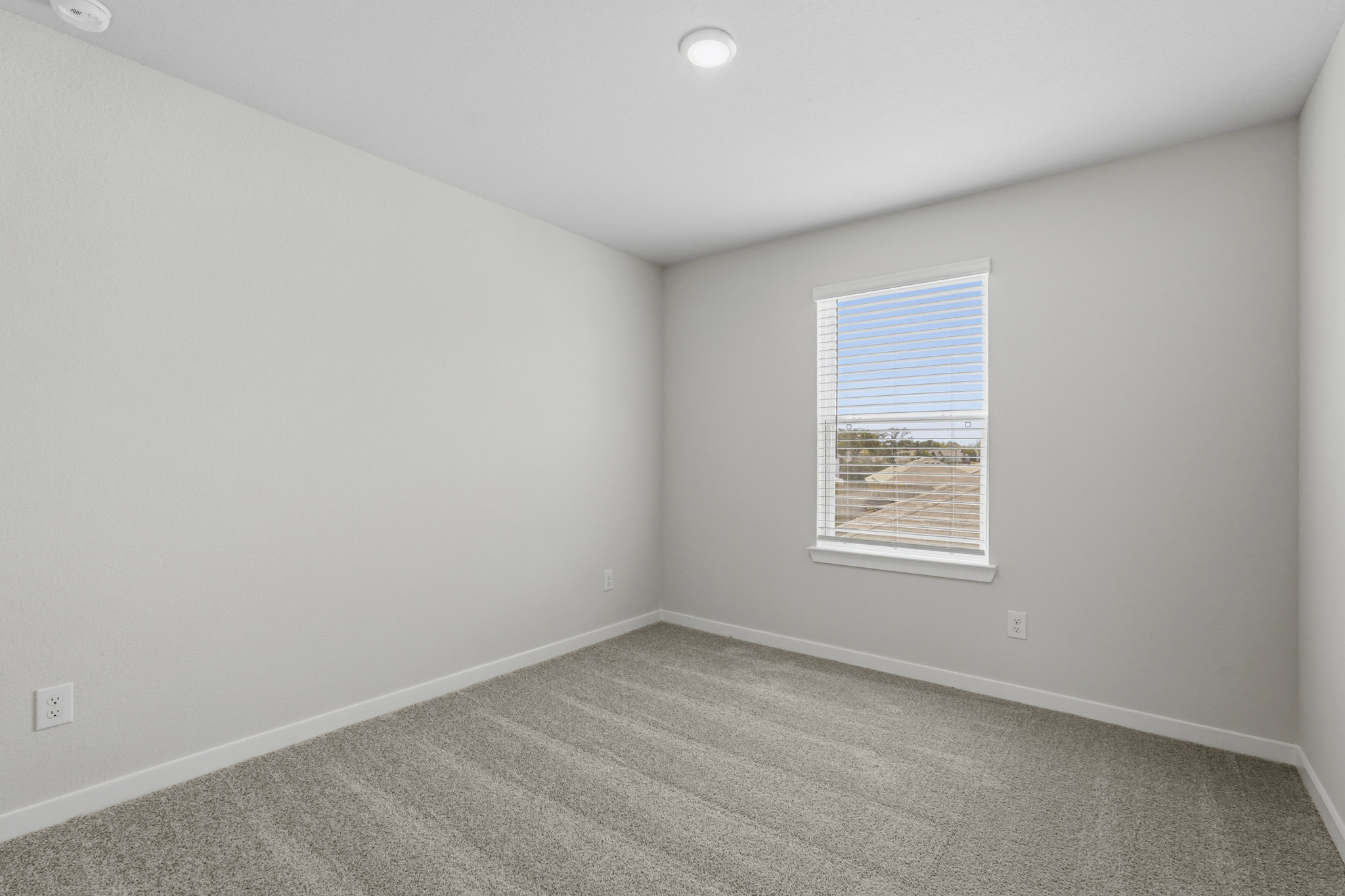 A room with a window and a carpet.