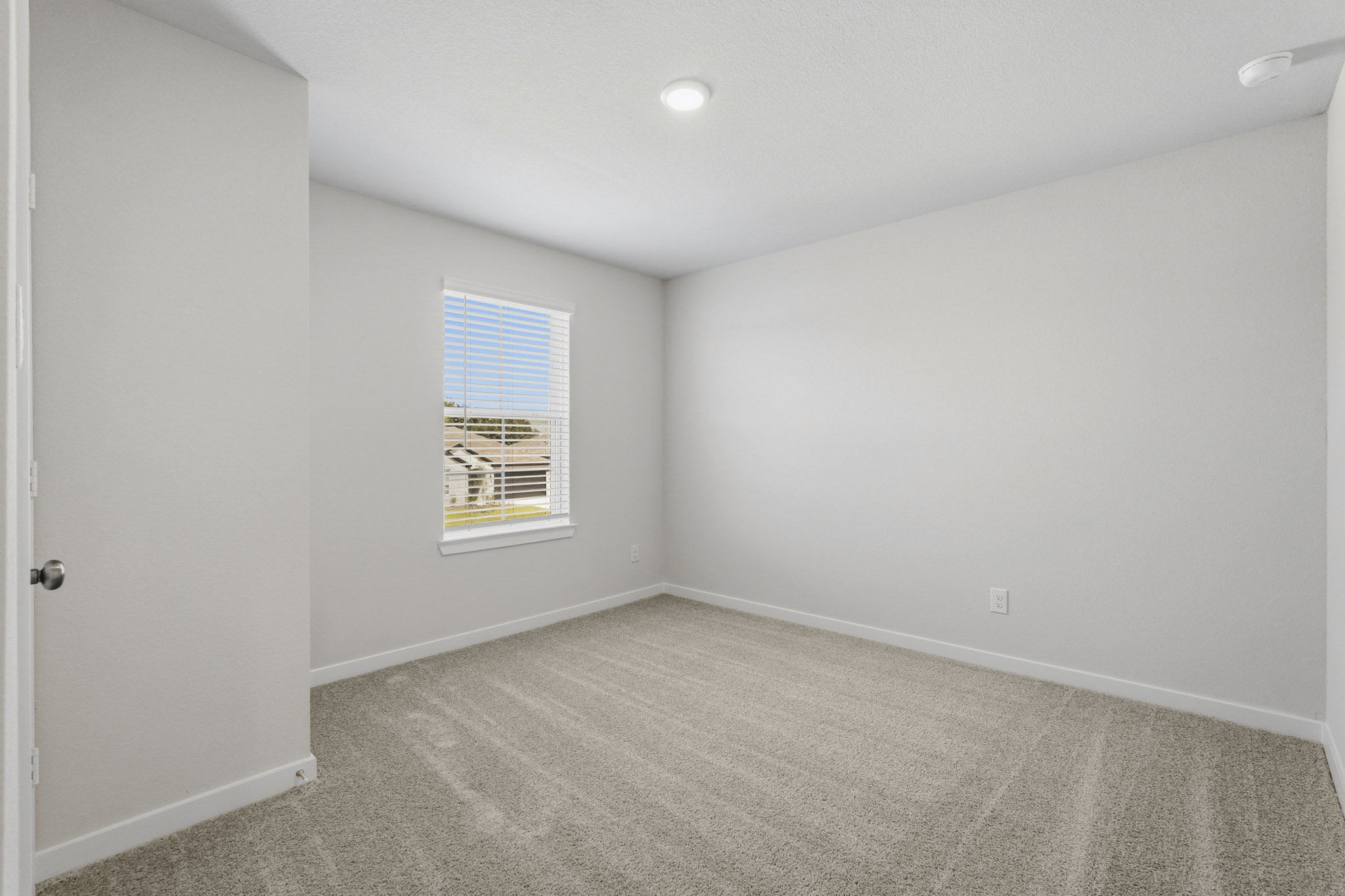 A room with a carpet and a window.