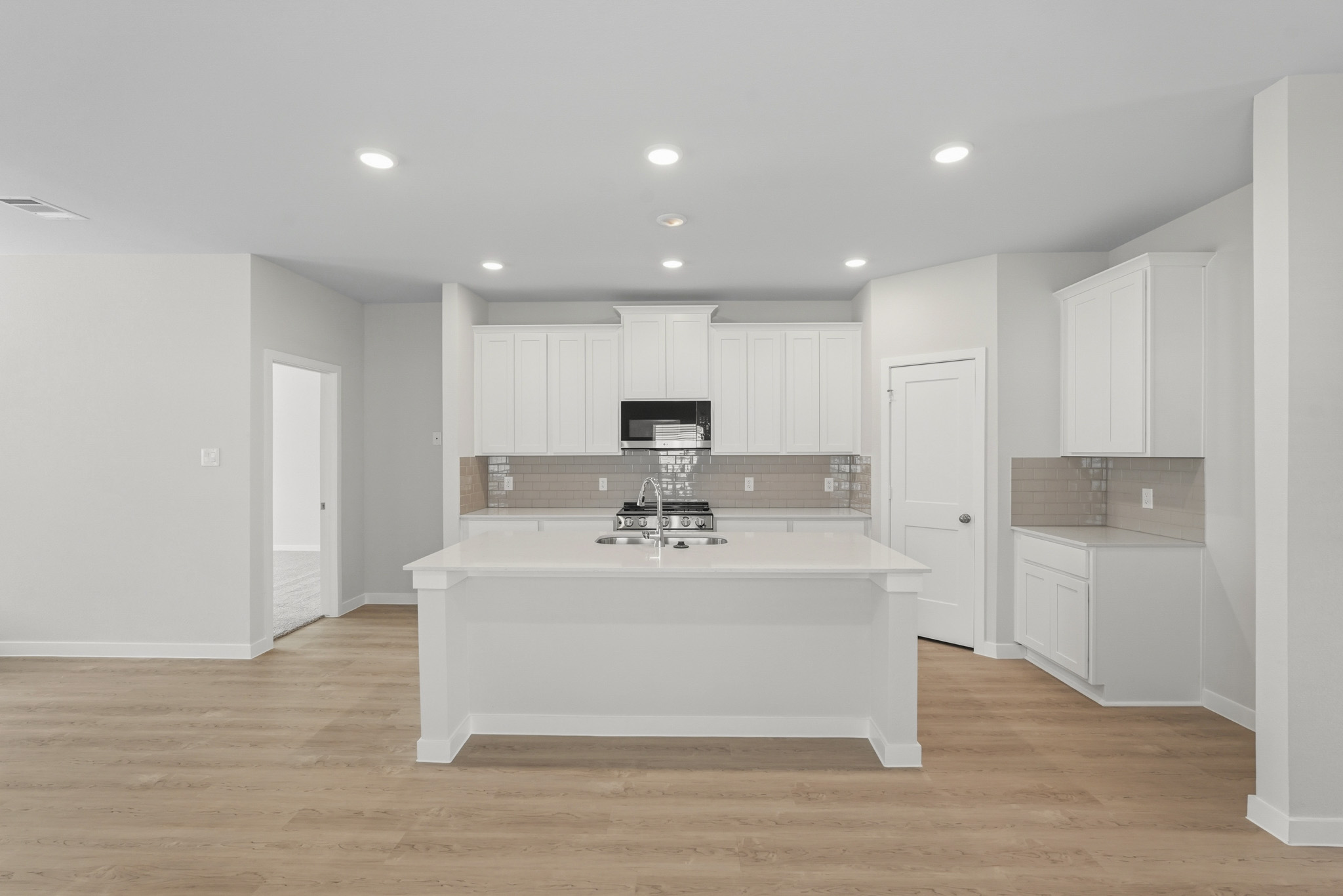 A kitchen with white cabinets.