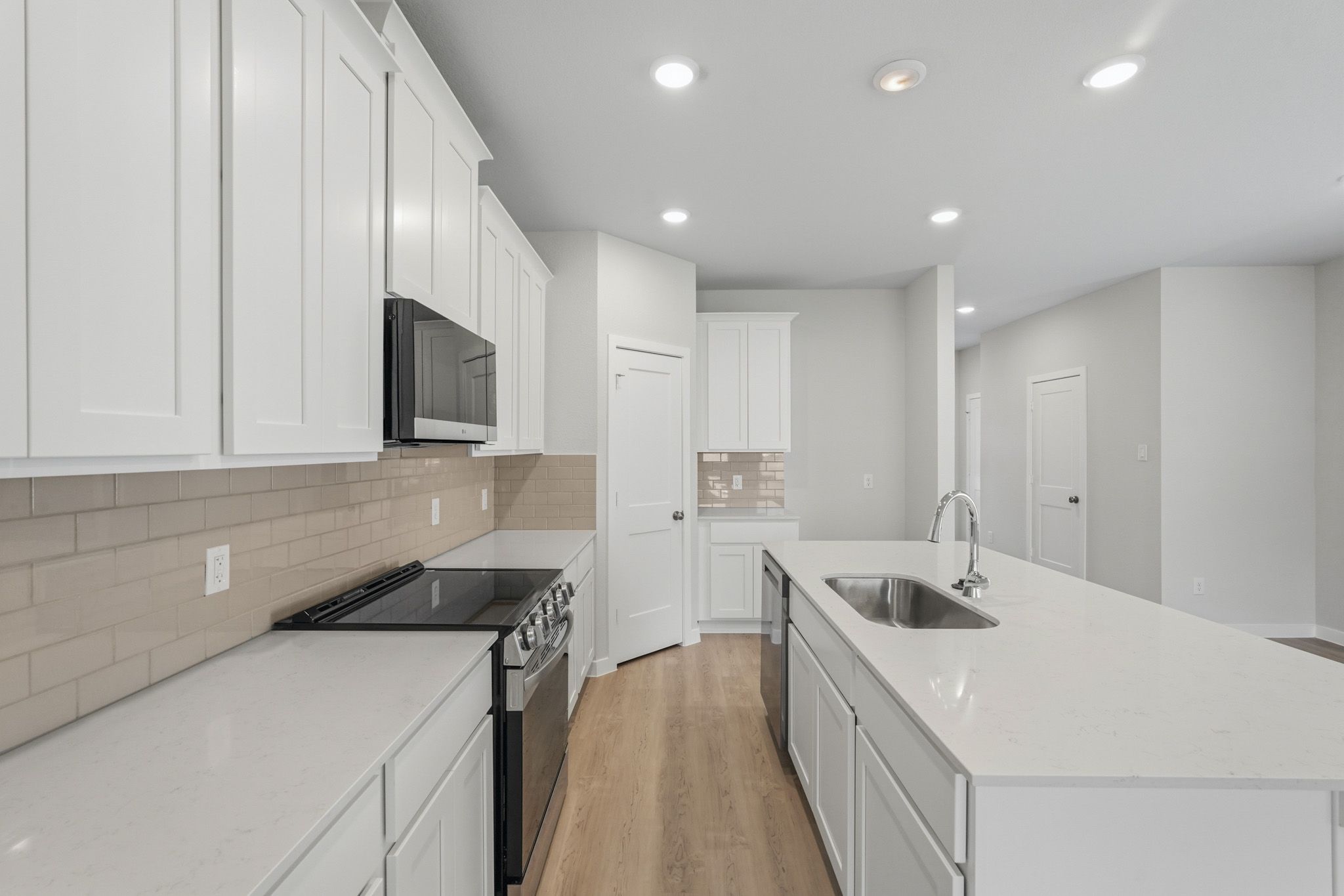 A kitchen with white cabinets.