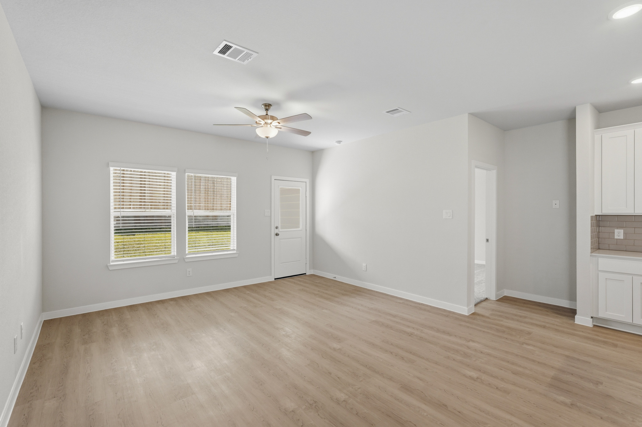 A room with a wood floor and a ceiling fan.