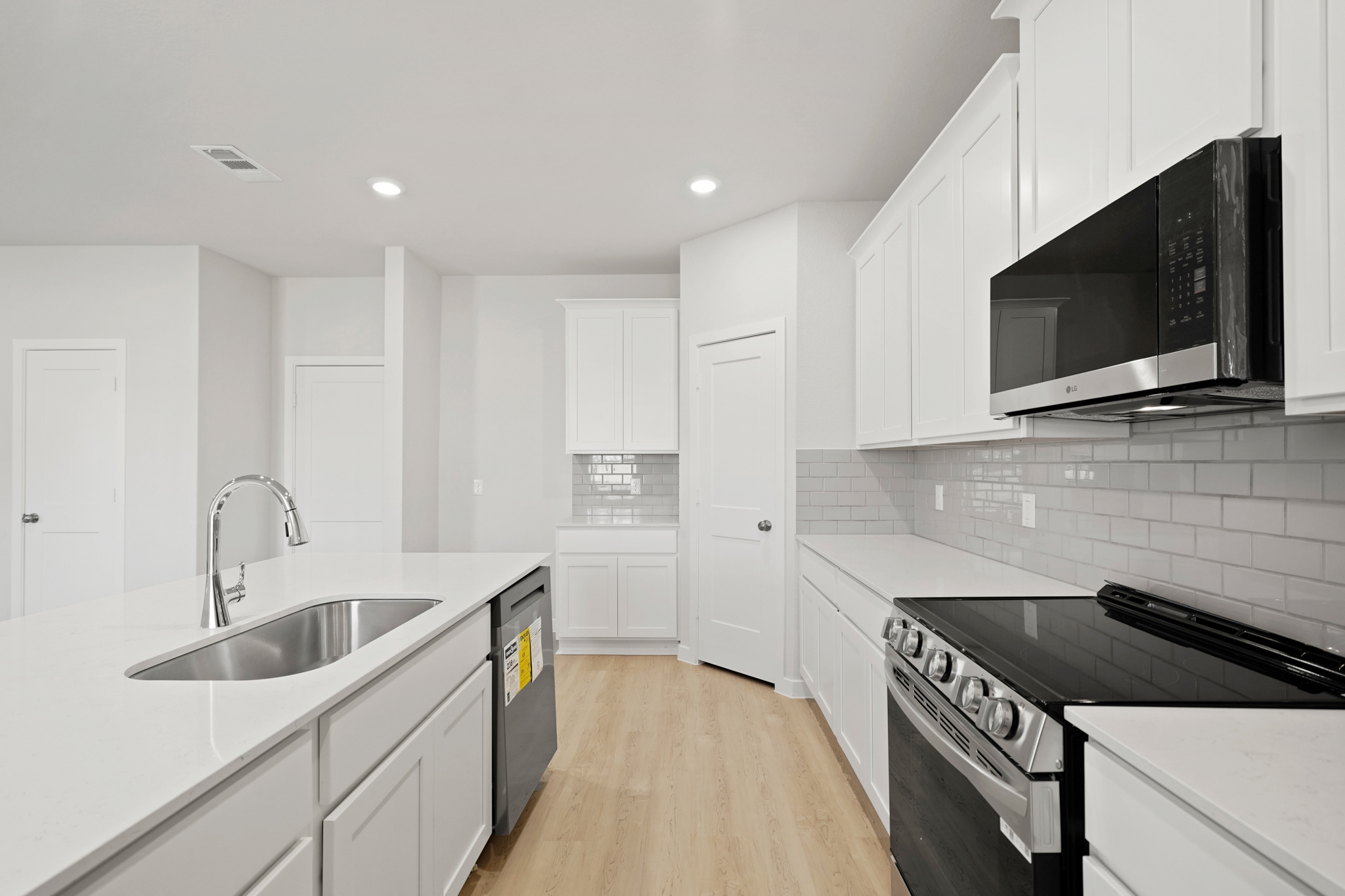 A kitchen with white cabinets.