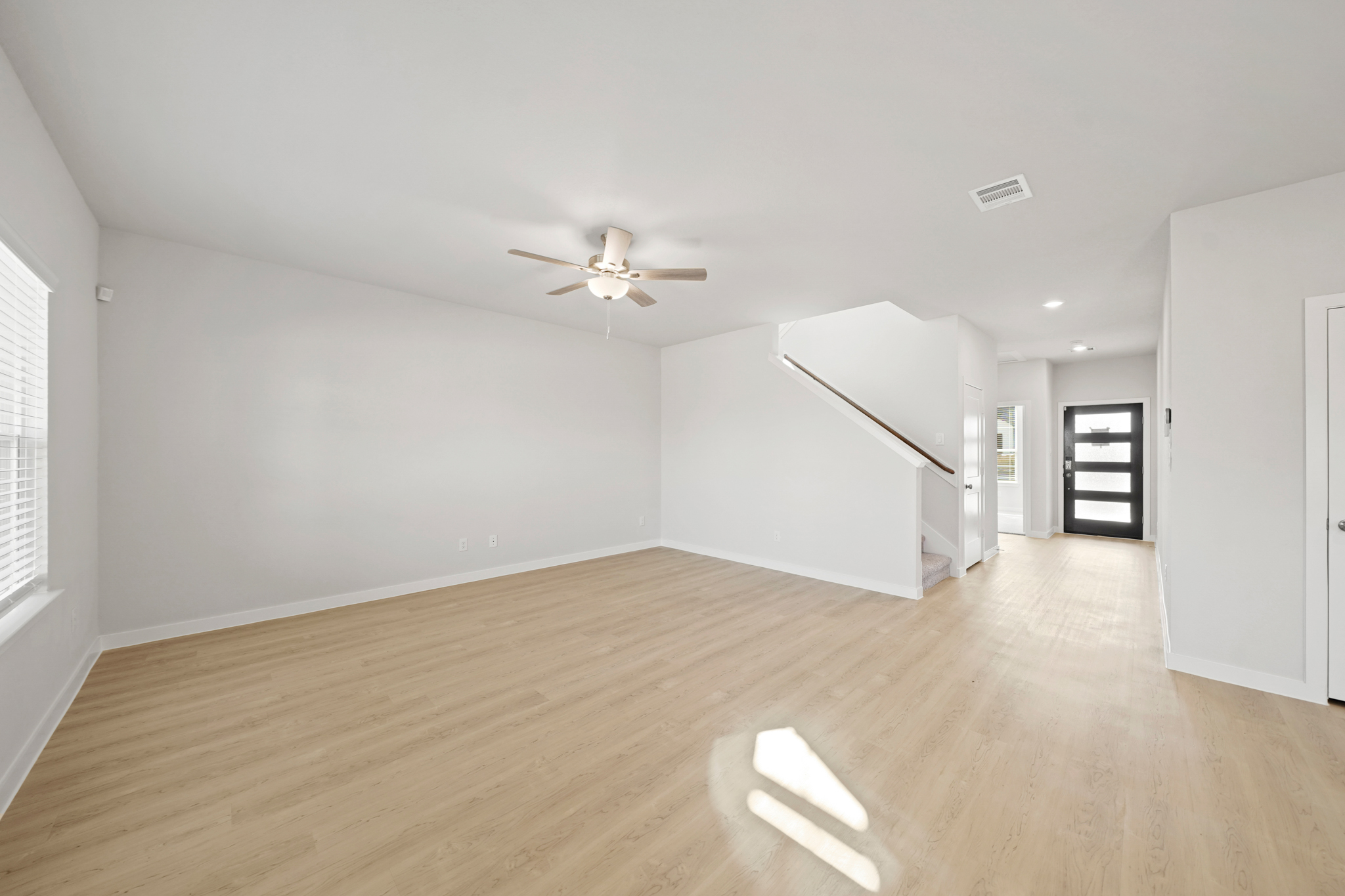 A room with a wood floor and a ceiling fan.