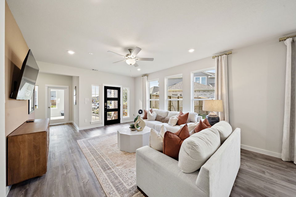 A living room with a large white couch and a large window.
