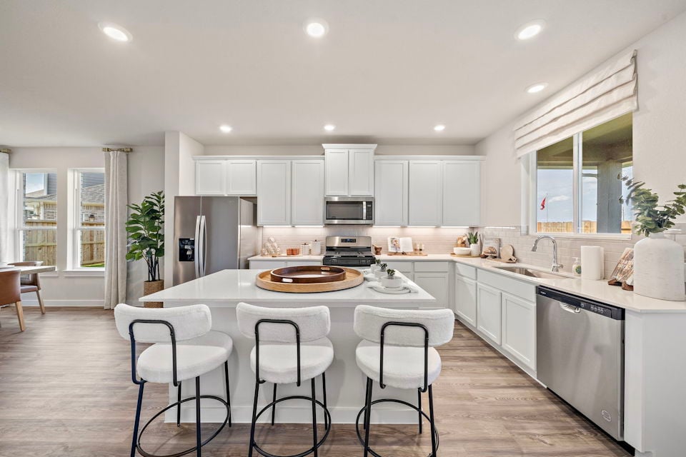 A kitchen with a table and chairs.
