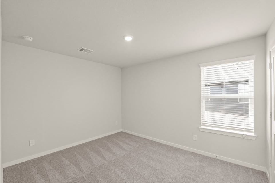 A room with a window and a carpet.