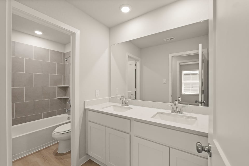 A bathroom with a large mirror.