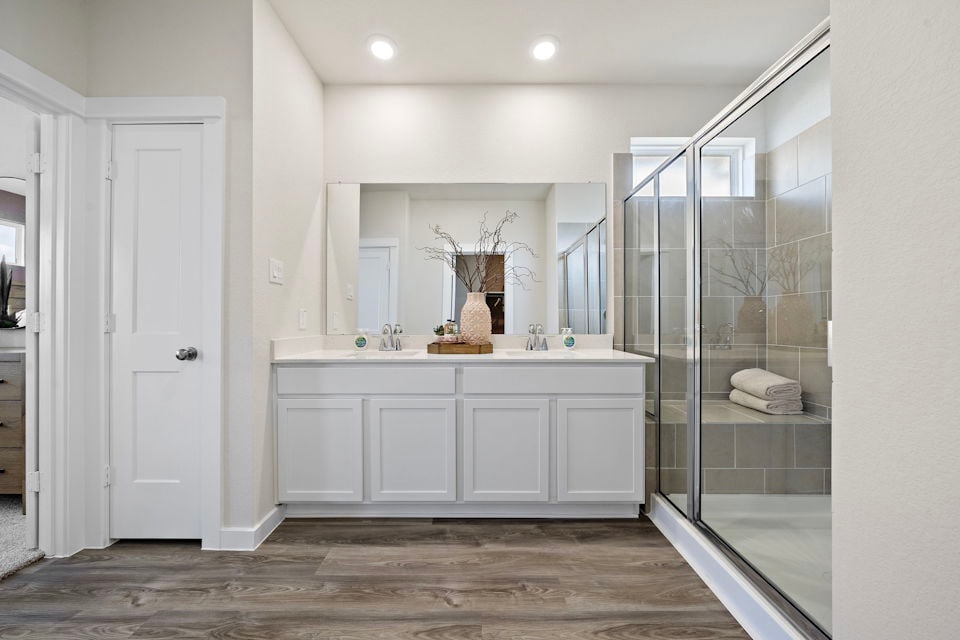 A bathroom with white cabinets.