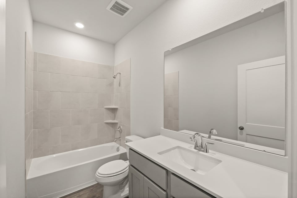 A bathroom with a tub sink and toilet.