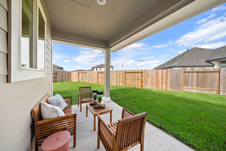 A patio with chairs and a table.