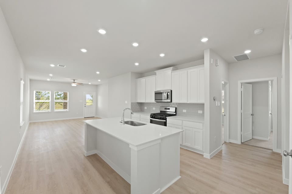 A kitchen with white cabinets.