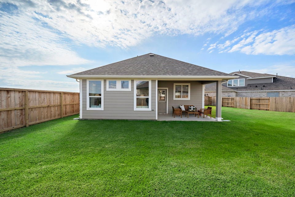 A house with a lawn and chairs.