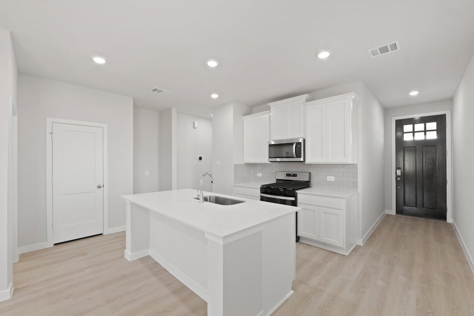 A kitchen with white cabinets.