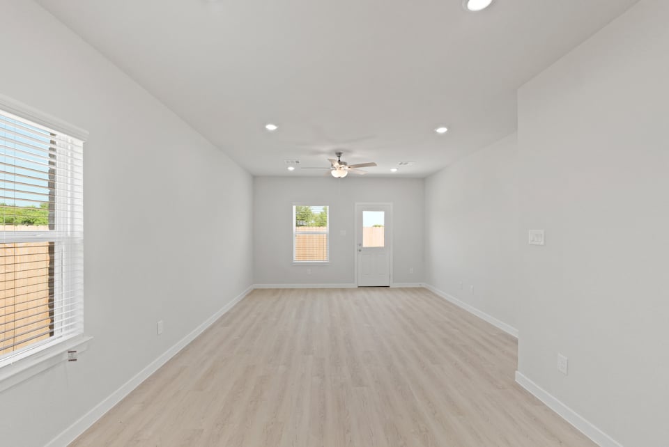 A room with a wood floor and a ceiling fan.