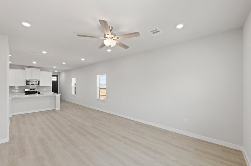 A large kitchen with a ceiling fan.