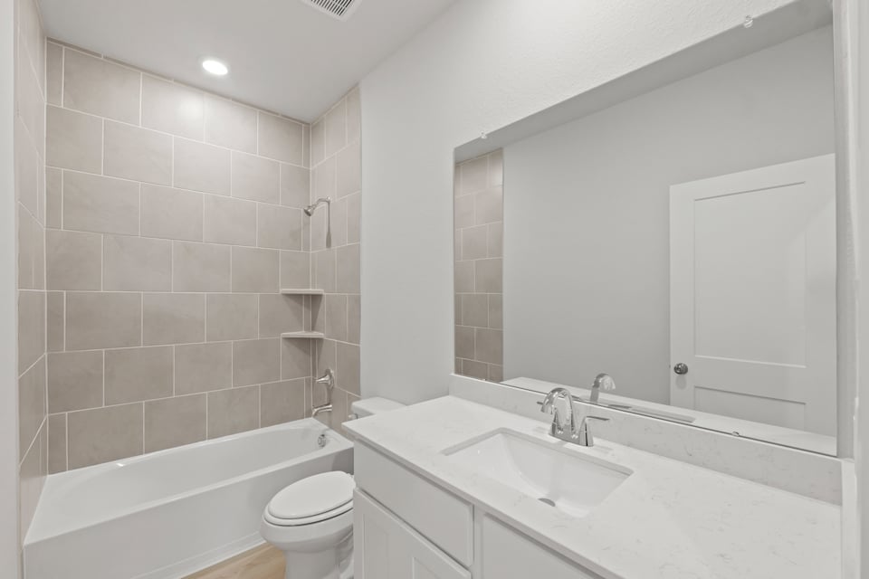 A bathroom with a tub sink and toilet.